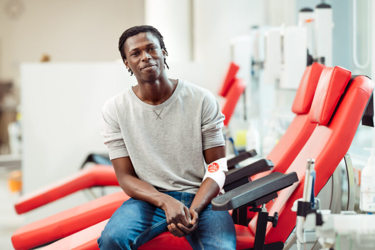 Blood donation, blood donor sitting on bed